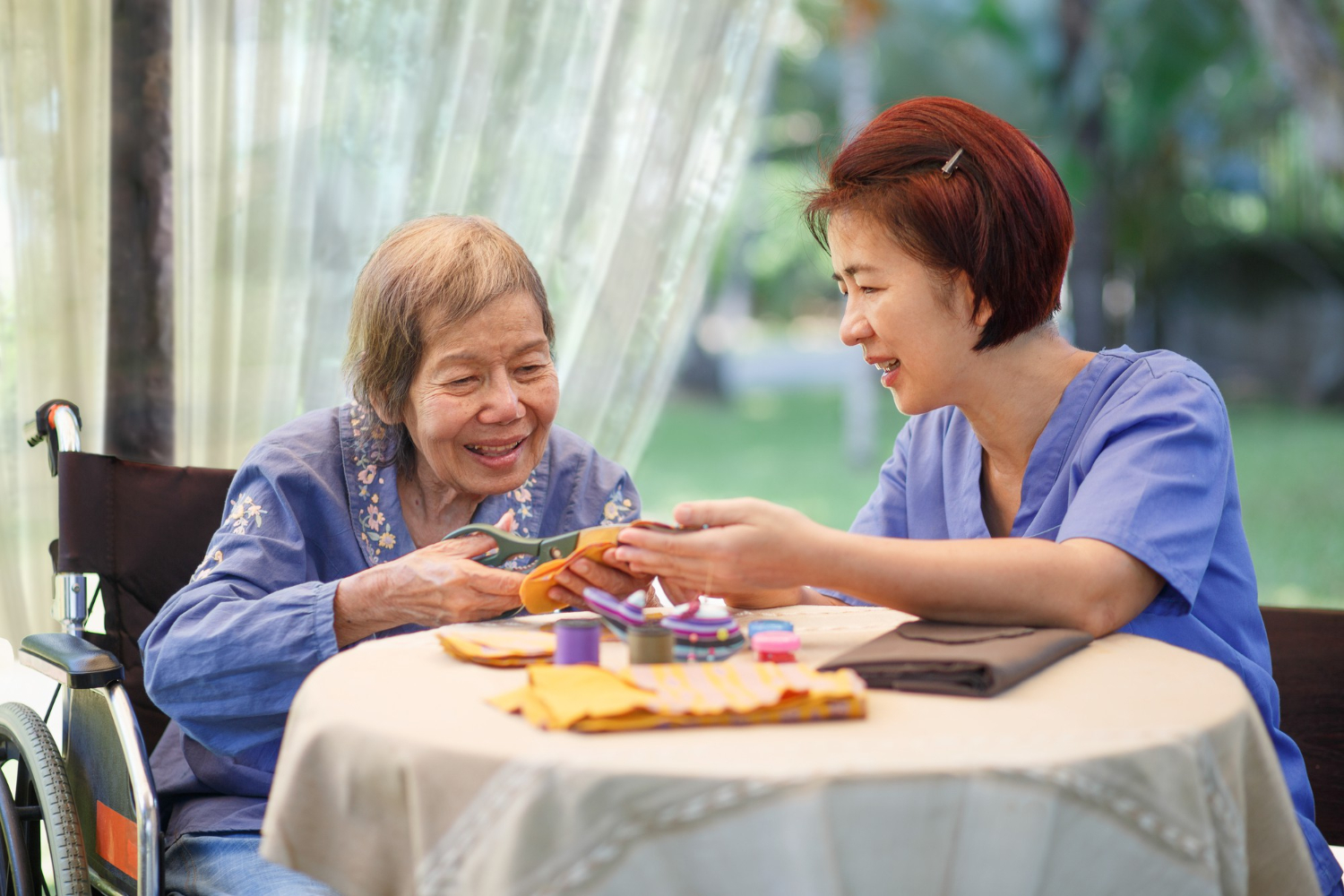 Signora anziana durante una terapia di stimolazione cognitiva con una caregiver