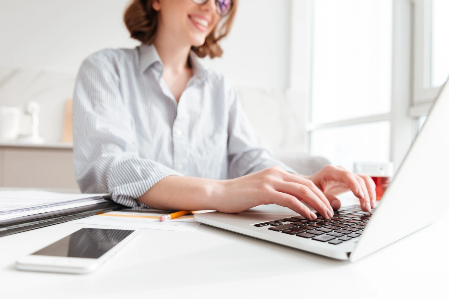 Ragazza neolaureata che segue un corso online con certificazione informatica al PC in casa